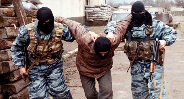 Российские силовики конвоируют задержанного в ходе боев в Гудермесе в октябре 1999 года. Фото: Adlan Khasanov/REUTERS Российские силовики конвоируют задержанного в ходе боев в Гудермесе в октябре 1999 года. Фото: Adlan Khasanov/REUTERS